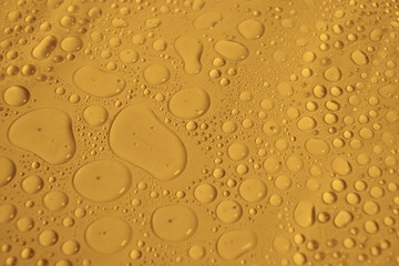 natural water drops on yellow golden background texture