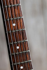 Electric guitar fretboard on a wooden background