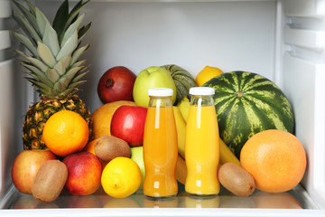 Open fridge full of fruits and bottles of juice © 5second