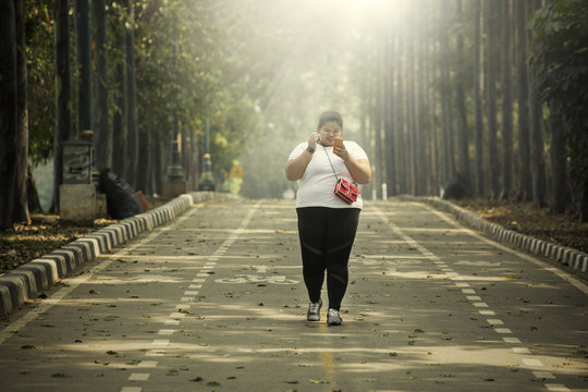 Fat woman holding phone on the road