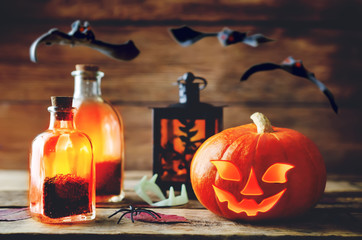 Glowing pumpkin with bats on dark wood background. Halloween concept