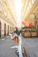 Woman traveling with red umbrella in Europe with backpack, sightseeing travel guide, tourism in...