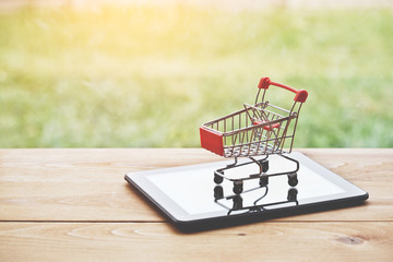 digital tablet  with trolley as symbol of online shopping and paying