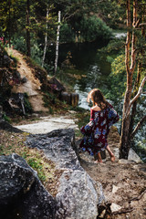 A little girl with wet hair runs barefoot along the rocks along the lake