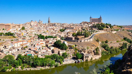 Fototapeta na wymiar Panoramic view of the center of Toledo with the Tajo (Tagus) river, Alcazar and tower of Toledo Cathedral. Toledo is a medieval town and a former capital of Spain