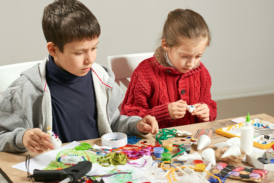 Childrens making decorations for new year holiday. Painting watercolors. Top view. Artwork workplace with creative accessories.