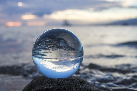 Wave on Beach and Boats on Horizon at Sunset in Glass Ball