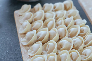 Dumplings with mince meat on a wooden board. Close-up view