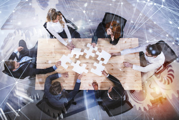 Teamwork of partners. Concept of integration and startup with puzzle pieces and gear overlay....