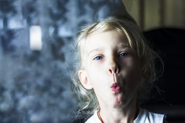 Little blonde Girl whistling. the background is divided into two halves. low cutting depth