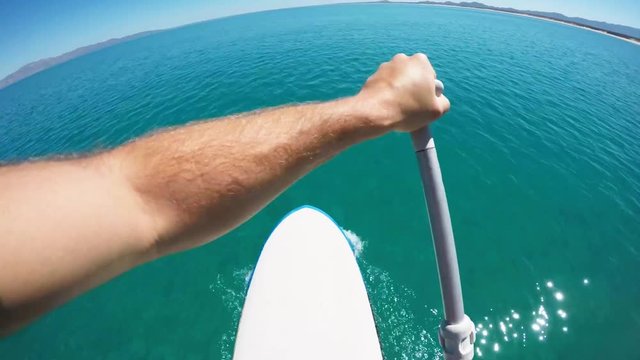 POV, man paddleboards in ocean