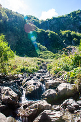 Fototapeta na wymiar Mountain Creek and beautiful waterfall. Cascade of motion water