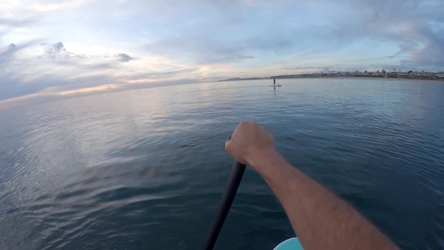 Paddle boarding on large body of water, POV