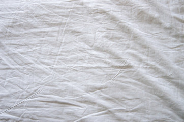 Naklejka na ściany i meble Top view of wrinkles on an unmade bed sheet after waking up in the morning.
