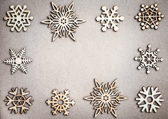 Wooden Decorative Snowflakes frame on Craft Paper Background, as the Christmas Decor. Tinted photo