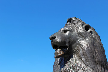 Bronze lion statue and clear blue sky in the background