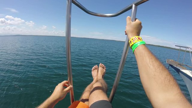 Hanging legs over bow of boat, POV