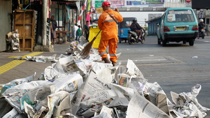 Sweeper cleaning road from newspaper garbage