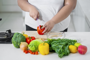 Unknown woman cutting a paprika
