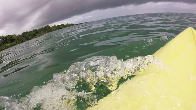 POV, surfer paddles out to sea