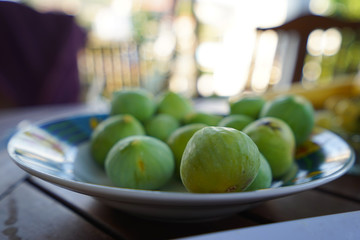 Green food figs at plate on the table