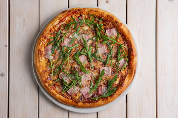 Pizza with bacon, bell pepper, onion and arugula