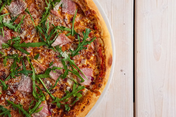 Pizza with bacon, bell pepper, onion and arugula