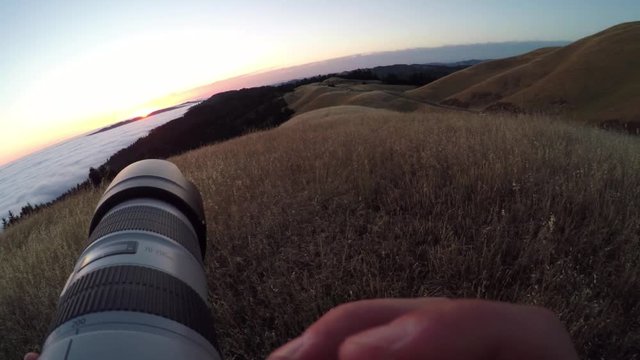 Taking pictures of scenic sunset, POV