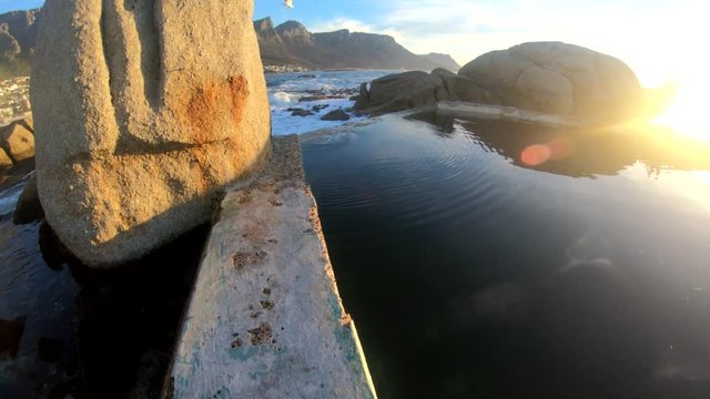 POV, sun sets over tidepool in Cape Town