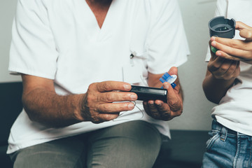 Hands of a doctor holding an insulin pump
