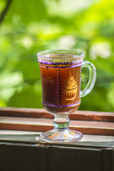 glass of Irish coffee on beautiful green natural background.