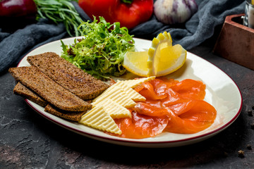 Salmon with butter and bread on a plate