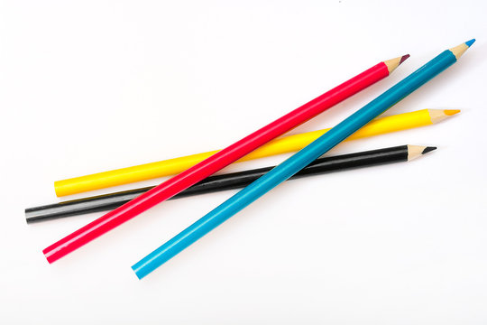 Four colored pencils. The colors cyan, magenta, yellow and black. The concept of polygraphy.
