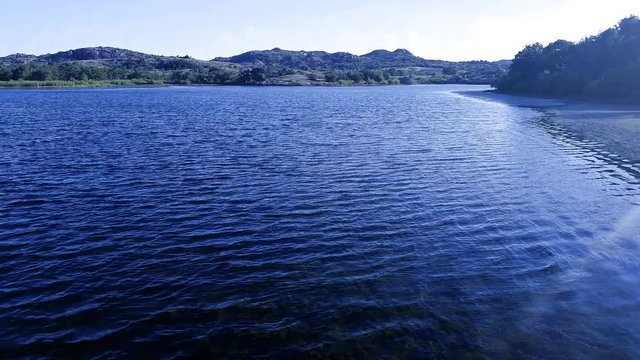walking over clear water lake with hydrilla reaching to surface.