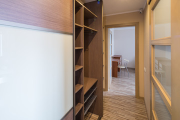 Interior of the flat. Warm tones, wooden floor. Built-in wardrobe