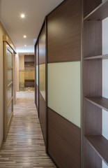 Interior of the flat. Warm tones, wooden floor. Built-in wardrobe