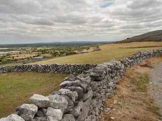 Irish country landscape, fields, old dry stone fences, cloudy sky, Burren region, Ireland, 