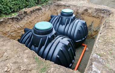 Two plastic underground storage tanks placed below ground for harvesting rainwater. The underground water septic tanks, for use as ecological recycling rainwater. Tank for home water harvest. - obrazy, fototapety, plakaty