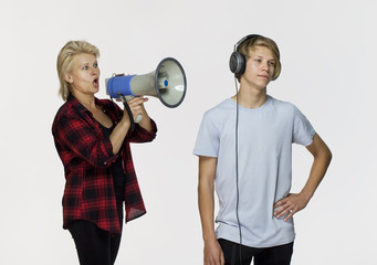 Misunderstandings in family. Angry mother with megaphone talking to her male teenager