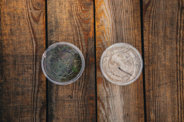 Container with white maggots on wooden background White worms used as fishing bait.