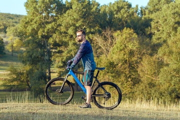 Fototapeta premium Cyclist in shorts and jersey on a modern carbon hardtail bike with an air suspension fork