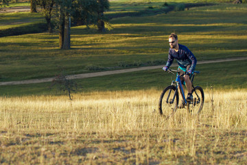 Cyclist in shorts and jersey on a modern carbon hardtail bike with an air suspension fork