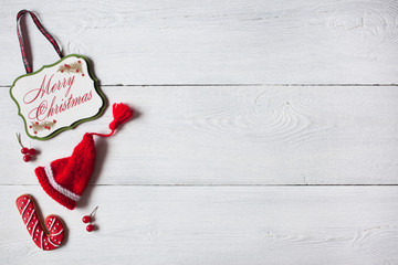 Christmas wooden white background, congratulation, red cap and berries