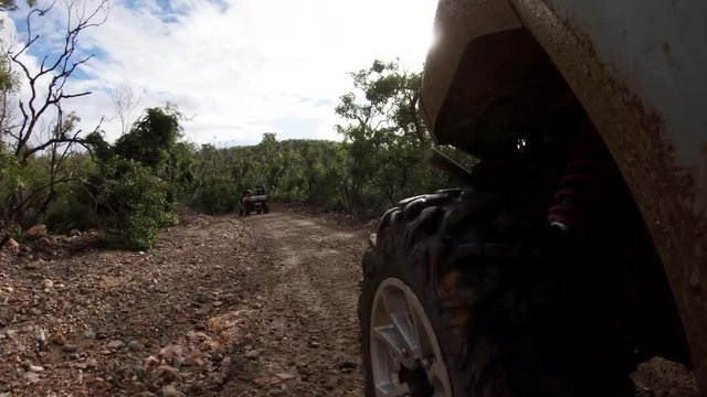 Close up POV, driving ATV on muddy trail