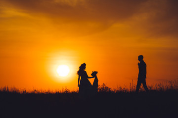 Obraz na płótnie Canvas Silhouette of bride and groom at sunset.