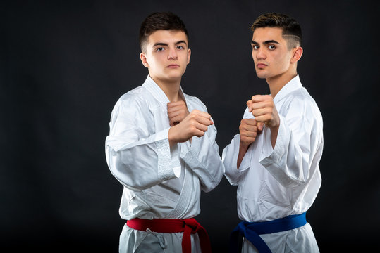 two guys karate on a dark background