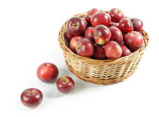 Wiklinowy kosz pełen czerwonych jabłek