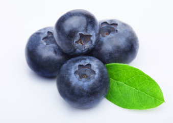 Fresh raw organic blueberries with leaf on white background. Macro close up