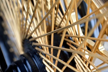 Motorcycle wheel abstract, shiny gold colored spokes and patterns