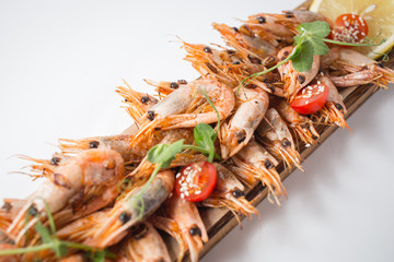 Lots of shrimps on the wooden board with lemon